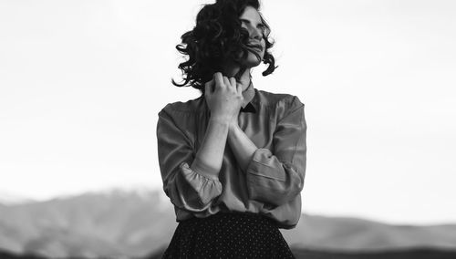 Midsection of woman standing against clear sky