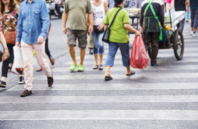 Low section of people walking on crosswalk