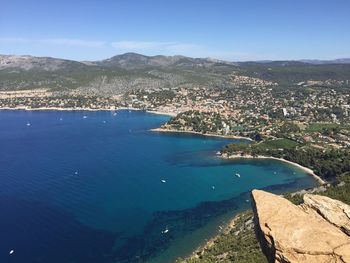High angle view of sea and mountains against clear blue sky