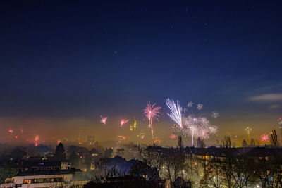 Firework display over illuminated buildings in city at night