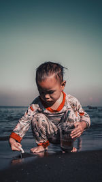 Boy on beach against sky