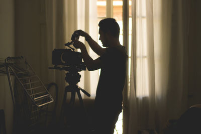 Side view of woman photographing at home