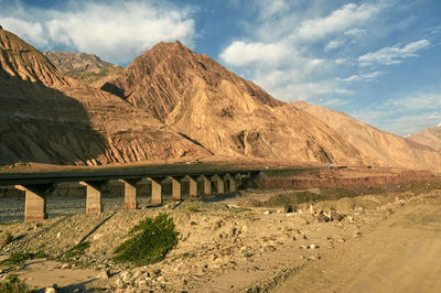 Arch bridge near mountains against sky