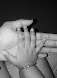 Close-up of mother holding baby hand