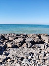 Scenic view of beach against clear blue sky