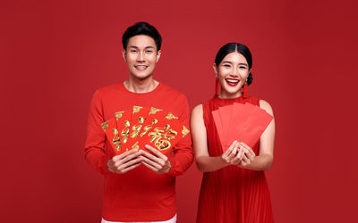 Portrait of a smiling young man against red background
