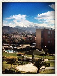 Buildings in town against cloudy sky