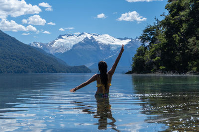 Rear view of woman standing in lake