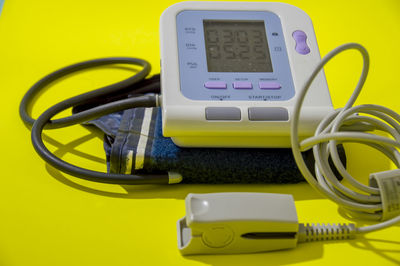 High angle view of stethoscope on yellow background