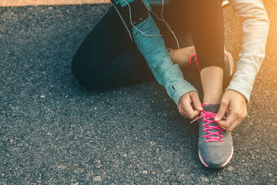 Low section of woman sitting on road