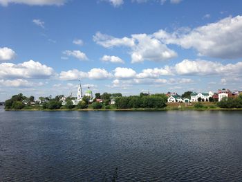 Scenic view of lake by buildings against sky