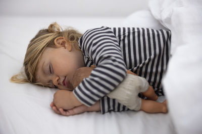 Cute baby sleeping on bed at home