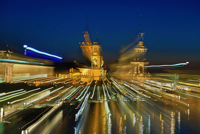 Light trails in city against clear sky at night