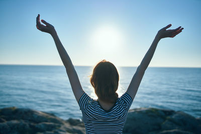 Rear view of woman looking at sea against sky