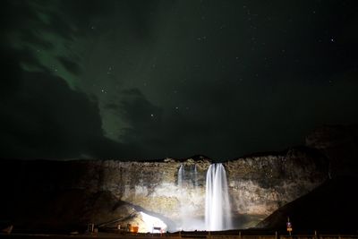 Low angle view of waterfall against sky at night