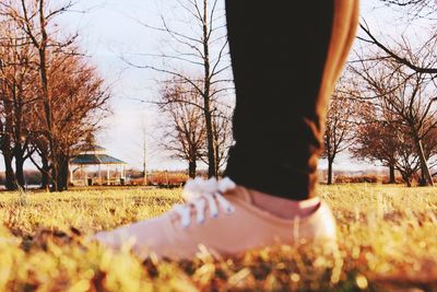 Low section of woman standing on field