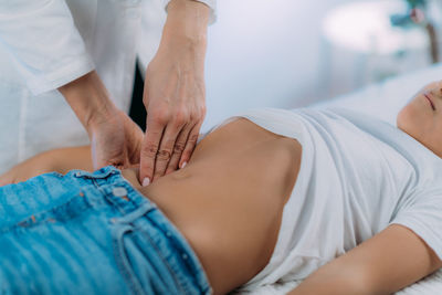 Pediatrician gastroenterologist, examining preschooler boys abdomen.