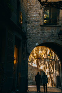 Rear view of people walking on building