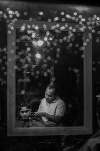 Man sitting in illuminated room at night