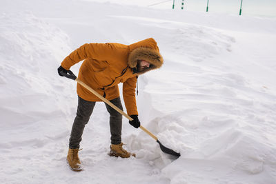 Low section of man skiing on snow covered field