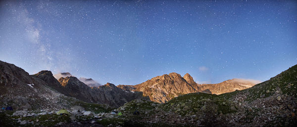 Scenic view of mountains against blue sky