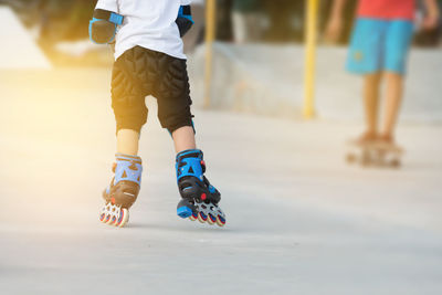 Low section of boys roller skating on street