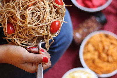 Midsection of woman holding noodles