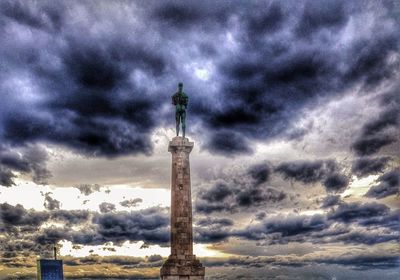 Statue of tower against cloudy sky