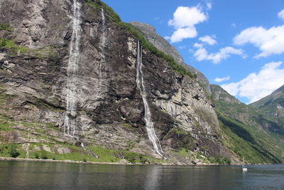 Scenic view of waterfall on mountain against sky