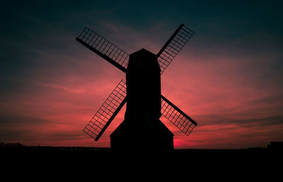 Silhouette of traditional windmill against sky at sunset