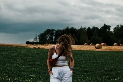 Full length of woman standing on field against sky