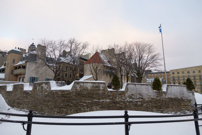 Snow covered houses and buildings against sky