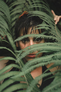 Close-up portrait of woman standing by plants