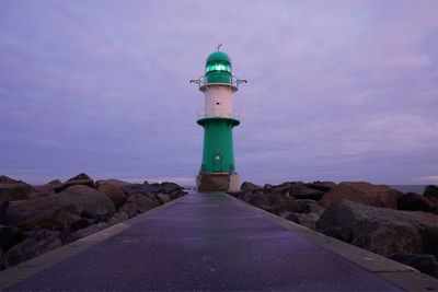 Lighthouse by sea against sky