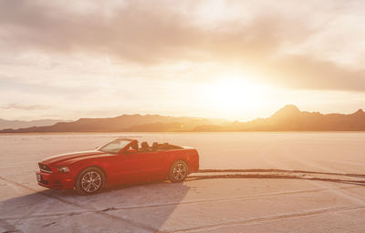 Car on mountain against sky during sunset