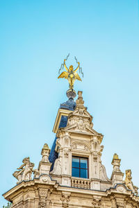 Low angle view of angel statue against blue sky