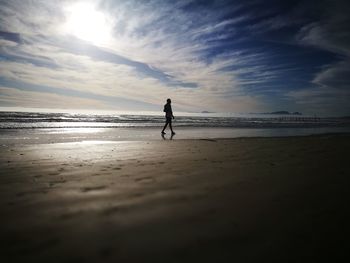 Silhouette of man walking on beach