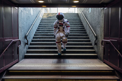 Male astronaut moving down from stairs