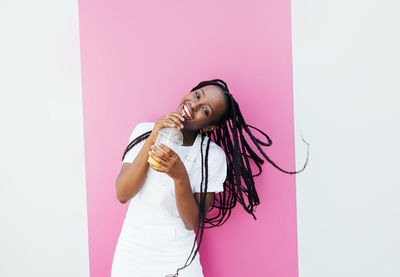 Smiling woman standing against colored background