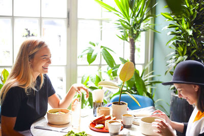 Smiling woman with girl having lunch