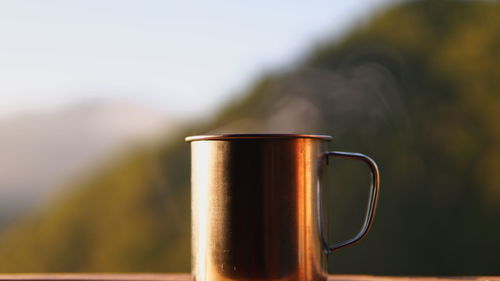 Close-up of mug against mountains