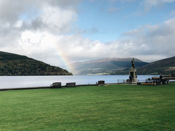 Scenic view of lake and mountains against cloudy sky