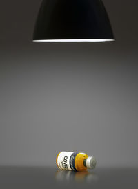 Close-up of light bulb on table against wall