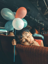 Sleeping girl holding balloons