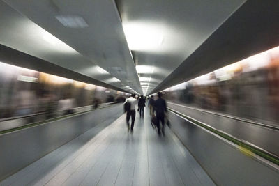 People walking on illuminated subway station