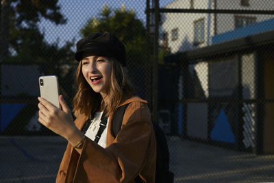 Portrait of smiling young woman using mobile phone