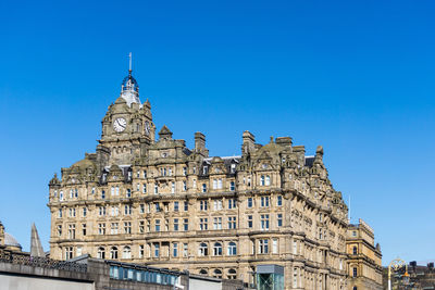 Low angle view of balmoral hotel against clear blue sky