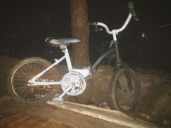 Close-up of bicycle parked on road at night