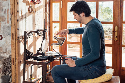 Side view of young man sitting on seat