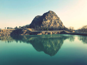 Scenic view of lake by mountains against clear sky